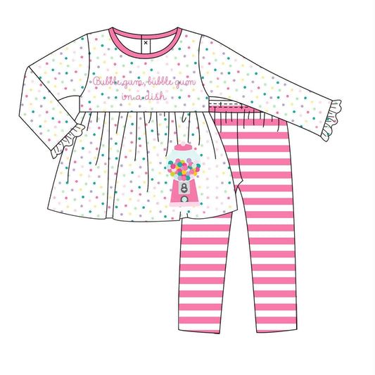 A children's two-piece outfit set shown as a flat illustration on a white background. The top is a long-sleeve white dress with pink trim, scattered pastel polka dots, and a pink gumball machine graphic with the words 'Bubble gum bubble gum madish.