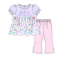 A children's two-piece outfit illustration featuring a light lavender top with ruffled sleeves, a multicolor candy print skirt with pink bow details, and light pink pants, shown on a plain white background.